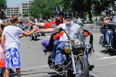 Kids give motorcycle riders a high five